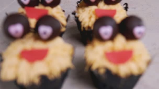 Muffin con ojos de chocolate y sonrisa roja. Concepto de Halloween. Dulce monstruo — Vídeo de stock