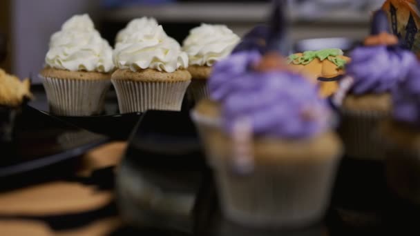 Cupcakes con sombrero glaseado y patas. Delicioso Muffin como bruja. Concepto Halloween — Vídeos de Stock