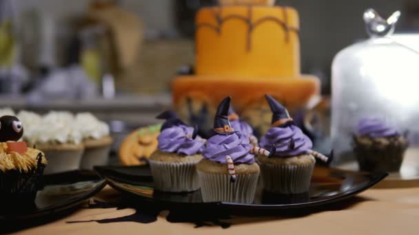 Cakejes met slagroom hoed en benen. Heerlijke Muffin als heks. Halloween concept — Stockvideo