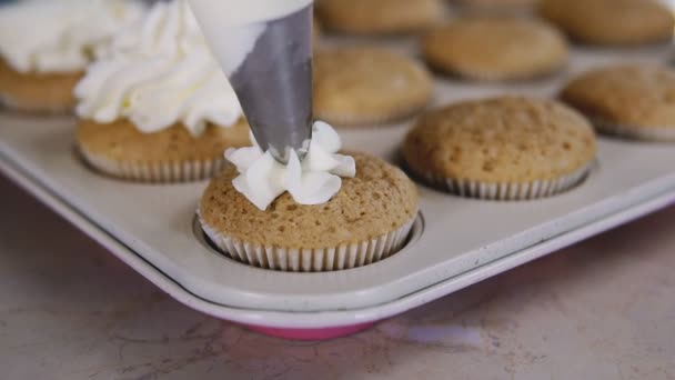 Shot de manos de las mujeres poniendo crema de mantequilla en pasteles sabrosos, concepto de panadería casera — Vídeo de stock