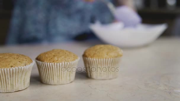 Housewife at background baking in kitchen delicious muffins. Close up with slide — Stock Video