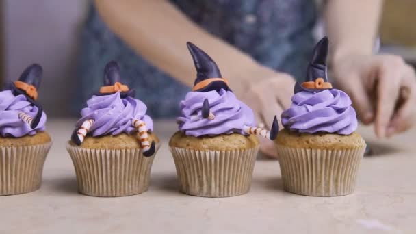 Decorare la tazza-torta con il cappello glassa e le gambe. Muffin come strega. Concetto Halloween — Video Stock