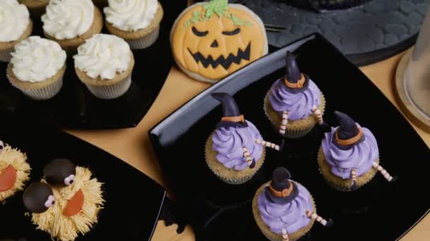 Cupcakes con sombrero glaseado y patas. Delicioso Muffin como bruja. Concepto Halloween — Vídeo de stock