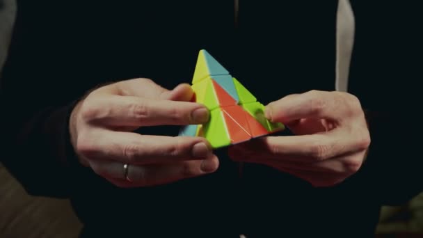 Minsk, Vitryssland - 20 November 2017: Pojkar händer lösa Rubiks Pyraminx — Stockvideo