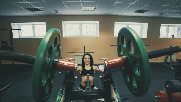 Красивая девушка делает упражнения на мышцах спины в блоке симулятор в фитнес-клубе — стоковое видео