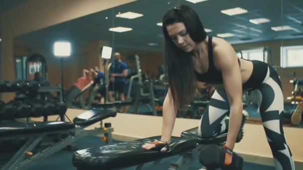 Csinos sportos nő csinál súlyzó pad gyakorolja a sport club — Stock videók