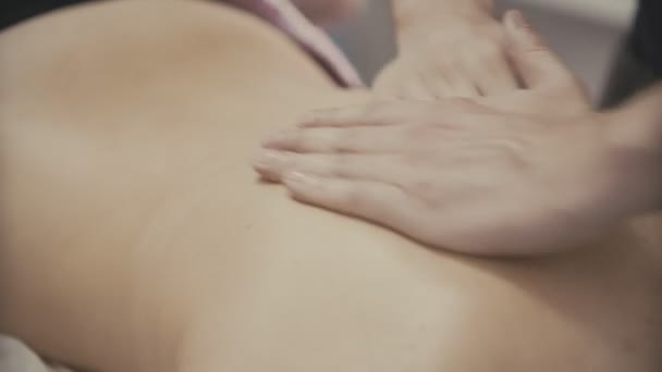 Masajista masajeando la espalda de la chica. Primeros planos manos de masajista . — Vídeos de Stock
