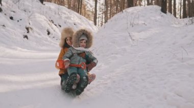 Genç anne ve küçük kızı kızak kış Park eğlenmek