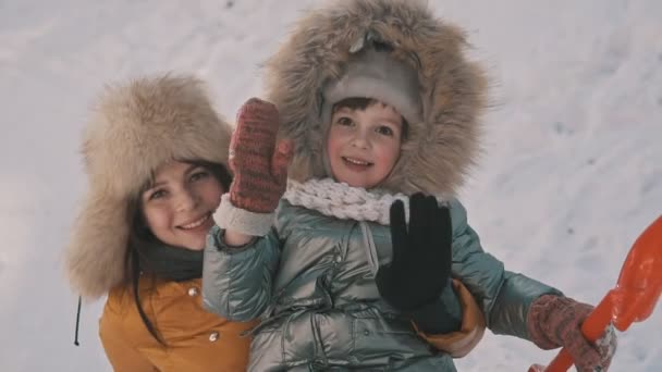 Матері проведення милий маленька дочка насолоджуючись холодний сонячної погоди в зимовий парк — стокове відео