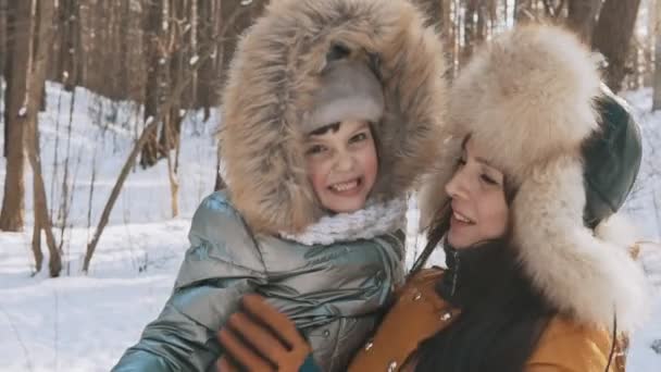 Mutter und kleine Tochter genießen kaltes, sonniges Wetter im Winterpark — Stockvideo