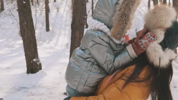Mutter und Tochter amüsieren sich bei kaltem, sonnigem Wetter im Winterpark im Freien — Stockvideo