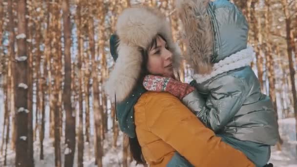 Mutter und Tochter amüsieren sich bei kaltem, sonnigem Wetter im Winterpark im Freien — Stockvideo