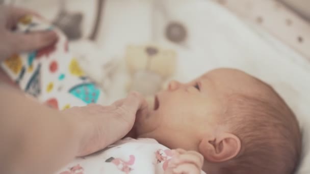 Niedliches Neugeborenes in weißer Kleidung im Bett — Stockvideo