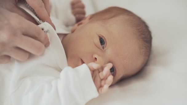 Lindo recién nacido bebé en cuna mirando cámara — Vídeo de stock