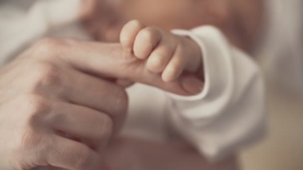 Молодая мать держит новорожденных за руку. Закрыть в замедленной съемке — стоковое видео