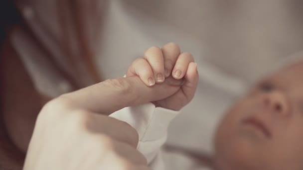 Young mother holding newborns hand. Close up in slow motion — Stock Video