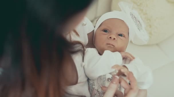 Schattige kleine pasgeboren baby in handen van de moeders. Close-up shot binnenshuis — Stockvideo