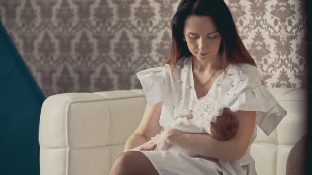 Jovem mãe segura as mãos pequeno bebê recém-nascido bonito. Fechar tiro dentro de casa . — Vídeo de Stock