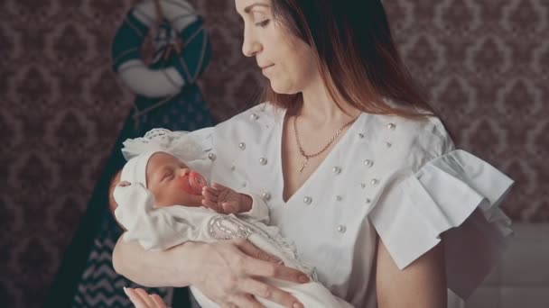 Joven madre tiene en las manos pequeño bebé recién nacido. Primer plano tiro en el interior . — Vídeos de Stock