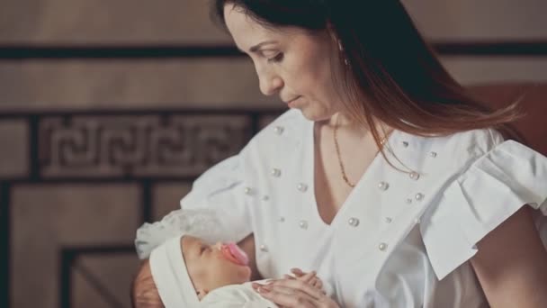Adorable little newborn baby in mothers arms. Close up shot indoors — Stock Video