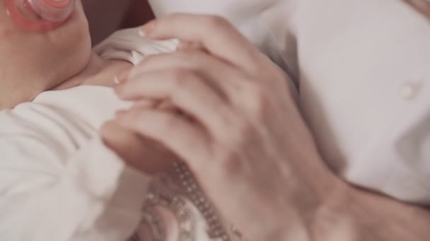 Молодая мать держит новорожденных за руку. Закрыть в замедленной съемке — стоковое видео