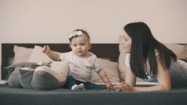 Anne ve kızı yatakta yan yana yatarken ve evde eğlenmek