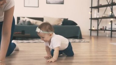 Genç anne ile odasında yerde sürünen küçük bebek kız