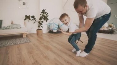 Baba ve oğul evde oyuncak at yavaş çekimde eğlenin