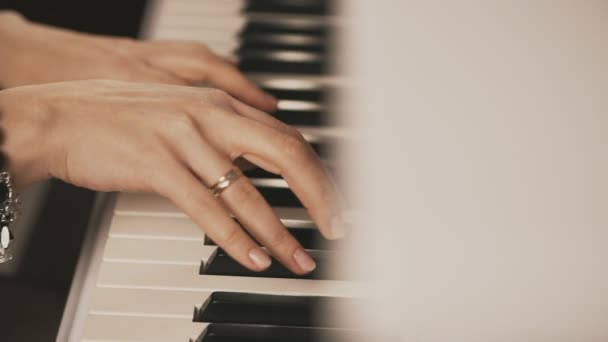 Female hands playing piano. Woman touches fingers on keys. Close up — Stock Video