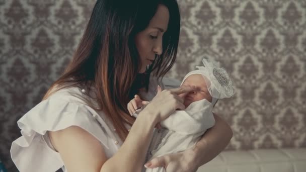 Очаровательный младенец на руках у матерей. Закрыть снимок в помещении — стоковое видео