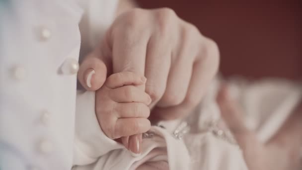 Young mother holding newborns hand. Close up in slow motion — Stock Video