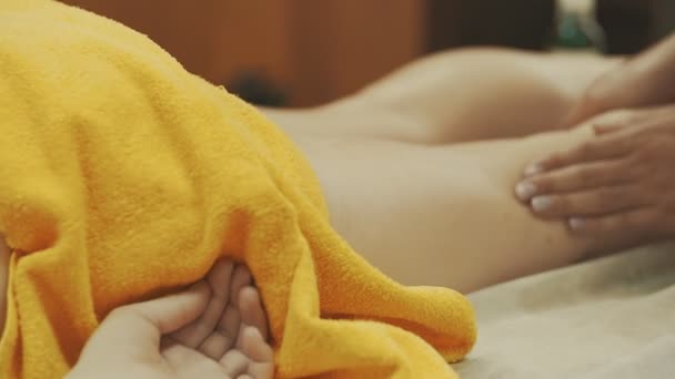 Mulher fazendo massagem nos pés com pedra quente, de perto. massagista amassa pé e perna — Vídeo de Stock