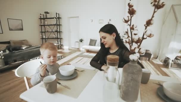 Feliz familia joven desayunando en la cocina de vacaciones en casa — Vídeo de stock