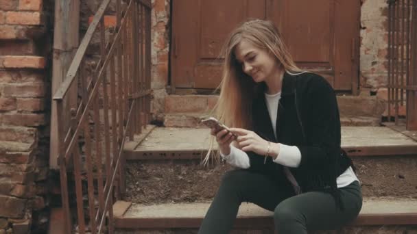 Mujer joven con smartphone al aire libre con copyspace — Vídeos de Stock