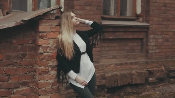 Женщина на городском фоне с подражательным пространством. Молодая женщина позирует на открытом воздухе — стоковое видео
