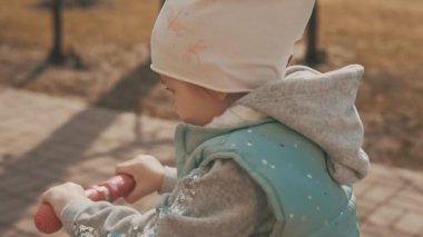 Ağır çekimde kaldırım, pembe scooter üzerinde binmek için küçük kız gider