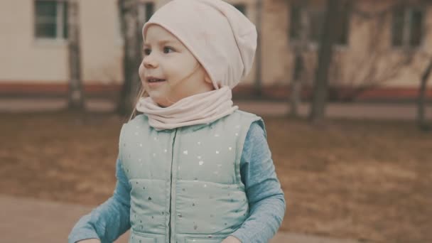 Feliz niña baila en la plaza de la ciudad en cámara lenta — Vídeos de Stock