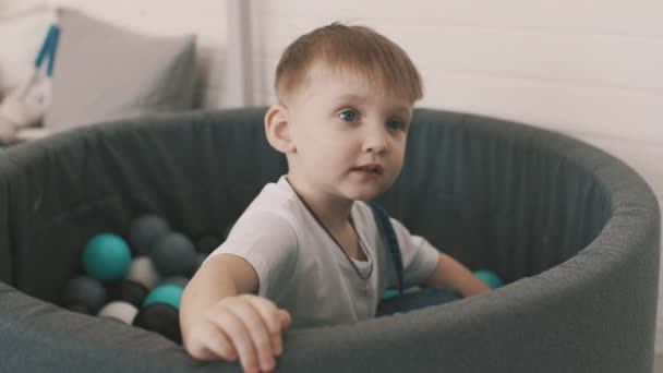 Little boy play in pool of coloured balls — Stock Video