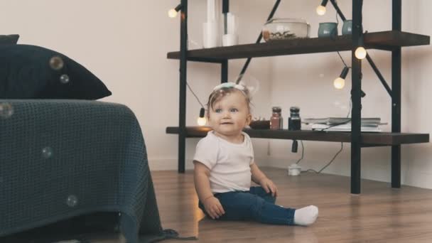 Маленькая девочка ползает по полу в комнате с молодой матерью — стоковое видео