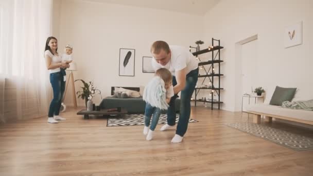 Junger Vater und kleiner Sohn amüsieren sich zu Hause mit Spielzeugpferd in Zeitlupe — Stockvideo