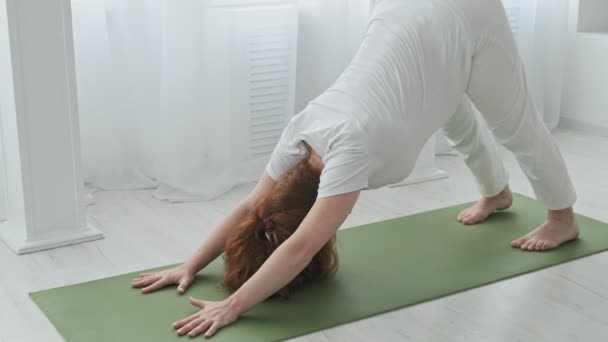 Ung rödhårig gravid kvinna som stretchar hemma. Gravid som gör yoga — Stockvideo