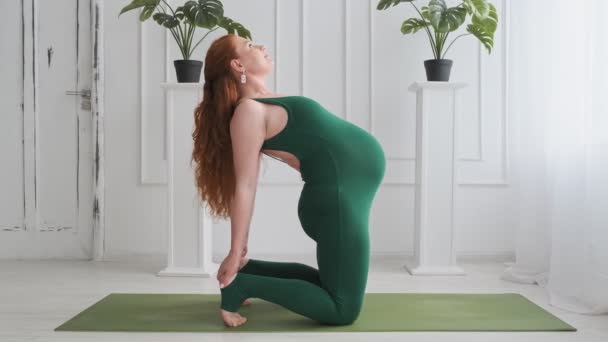 Fiatal várandós anya gyakorolja a jógát. Vöröshajú terhes jógázik. — Stock videók