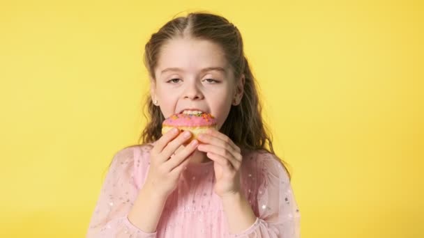 Kleines Hübsches Mädchen Das Donut Auf Gelbem Hintergrund Isst Nahaufnahme — Stockvideo