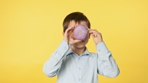 Feliz Chico Bonito Con Camisa Azul Jugando Con Donut Violeta — Vídeo de stock