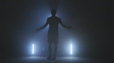 Smoky spor salonunda ısınırken atlama halatı kullanarak atlayan boksör. Genç boksör atlıyor