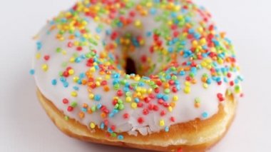 Lezzetli donut beyaz arka planda dönüyor. Uhd 'da dönen renkli donut