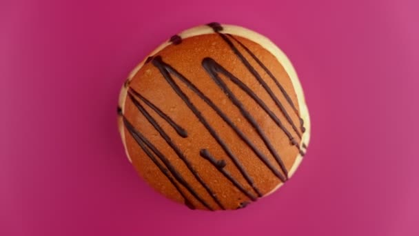 Top view of fresh doughnut rotating at pink background. Sweet donut spinning. — Stock Video