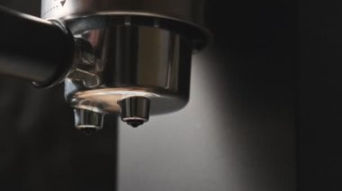 Makineden fincana kahve dolduruyorum. Kahveci espresso yaparken yakın plan.