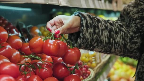 Žena kupující rajčata v supermarketu. Žena vybírá ekologickou zeleninu — Stock video