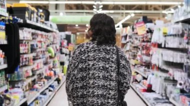 Alışveriş merkezinde tramvayı olan genç bir kadın. Arkadan bak. Atışı izle.